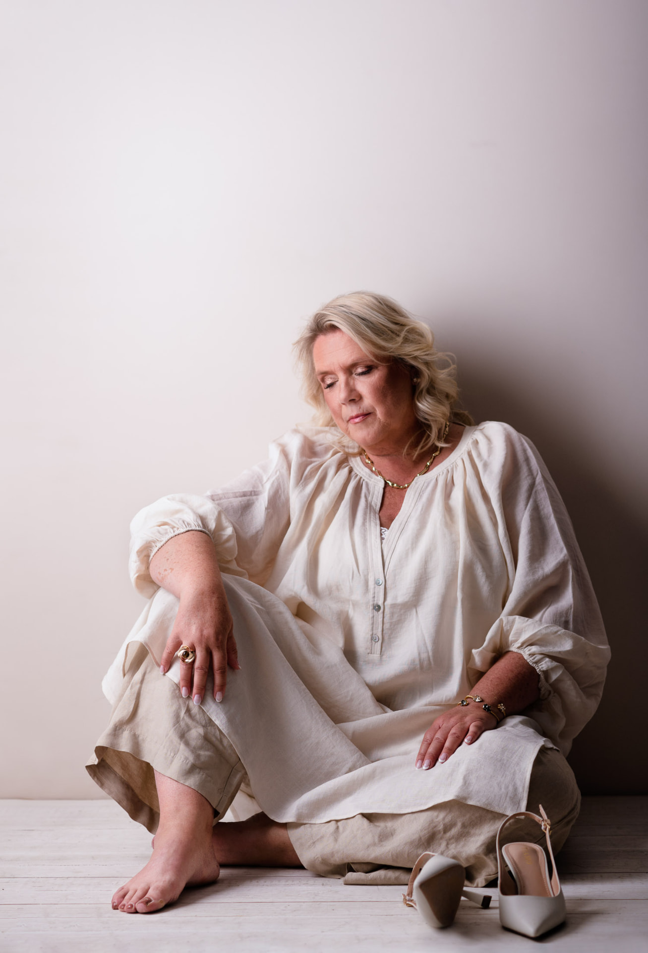 Camilla Ma Ra seated on the floor in linen, resting quietly